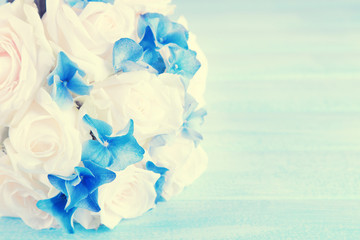 Beautiful wedding bouquet with roses on blue wooden table