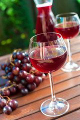 Two glasses of delicious homemade red wine with grape