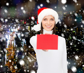 woman in santa helper hat with blank red card
