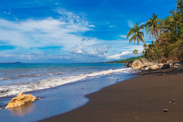 Beautiful tropical beach with black sand. Summer vacation concep