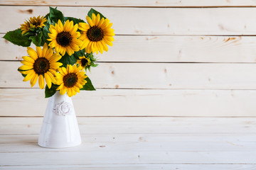 Naklejka premium Sunflowers in a vase on a rustic, gray background