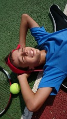 Niño tumbado en pista de tenis