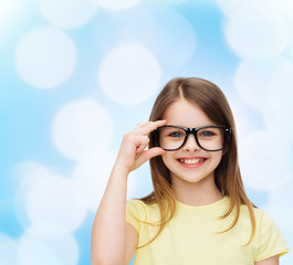 smiling cute little girl in black eyeglasses