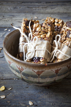homemade rustic granola bars with dried fruits on old bowl