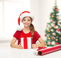 smiling girl in santa helper hat with gift box