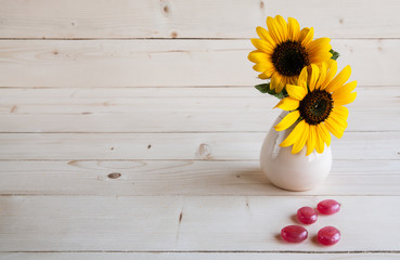 sunflower on a wooden background with red candy