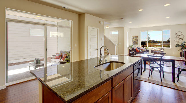 House interior with open floor plan. Kitchen island with granite