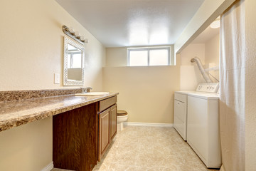 Fototapeta na wymiar Laundry room with granite counter top and cabinet