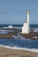 Lighthouse on the beach against blue sky