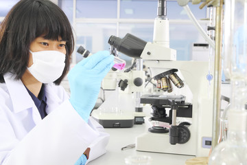 Naklejka na ściany i meble Chemist holding sample of liquid in lab or laboratory