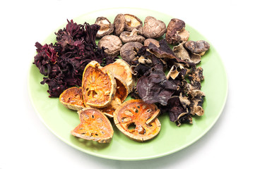Heap of dried  vegetable and fruit on green plate