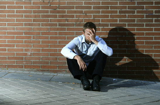 businessman jobless sitting depressed on street ground