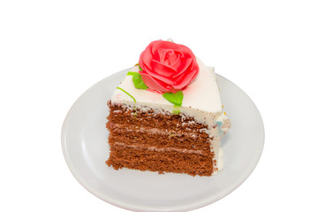 Slice of chocolate cream cake with rose Isolated on white backgr