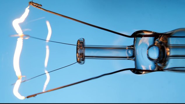 Close up on lightbulb flickers on blue background