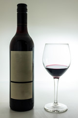 Black bottle of wine and wneglass