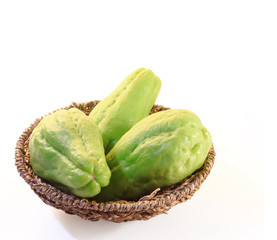 Chayote squash, also known as choko in basket on white