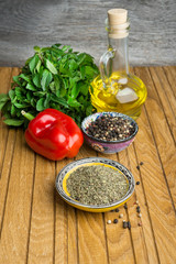 Spices and herbs in  bowls on wooden table.