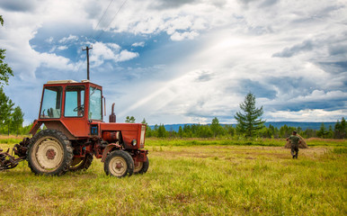 Трактор в поле на фоне красивого неба.