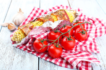 Grilled bacon wrapped corn on table, close-up