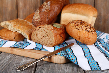 Composition of fresh baked bread, knife and kitchen towel,