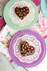 Delicious rainbow cakes on plates, on bright background