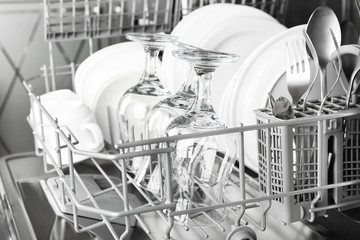 Open dishwasher with clean utensils in it