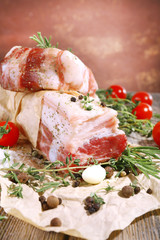 raw bacon with spices and tomatoes on wooden table