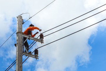 electrician working  repairing wire on electric power pole