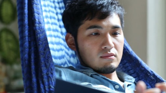 ハンモックで読書する男性1