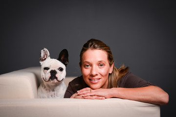 isolated studio shot of young woman with pet french bulldog