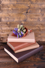 Books and wildflowers on wooden table on wooden wall background