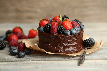 Tasty chocolate cake with different berries on wooden table