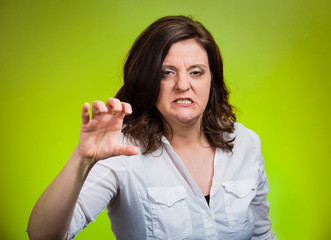 Unhappy angry middle aged woman on green background 