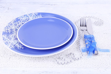 Blue plates, knife, fork, napkin and Christmas decoration