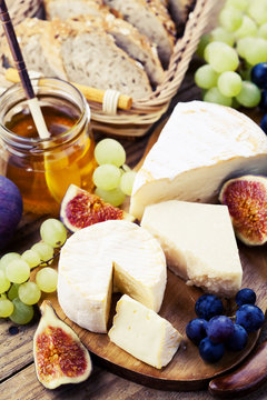 Cheese plate. Variety of cheese sorts with grapes and figs