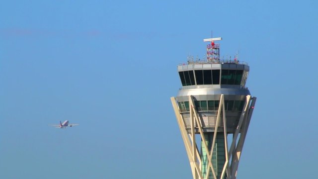 Barcelona Airport Control Tower with plane in sky
