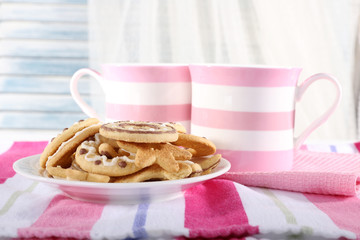 Two mugs of coffee with biscuits