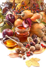 Honey, apples and autumn fruits on the white background