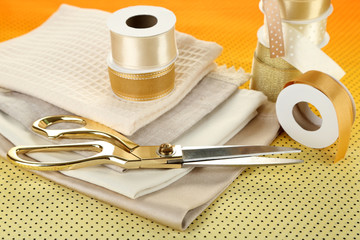 Ribbon with scissors and fabrics close up
