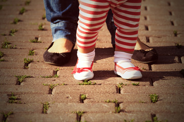 mother helping daughter to make first steps