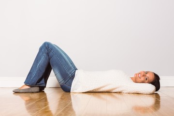 Fototapeta na wymiar Young woman lying on floor smiling