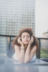 young beautiful long curly hair hipster woman listening music