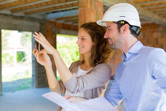Young woman and architect on construction site