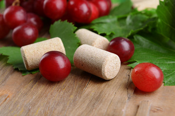 Wine bottle corks with grapes on table close-up