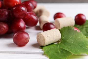 Wine bottle corks with grapes on table close-up