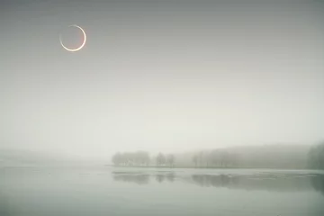 Rolgordijnen eclipse of the sun in the autumn mist. © Aliaksei