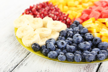 Sliced fruits on plate on wooden table