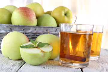 still life with apple cider and fresh apples on wooden table