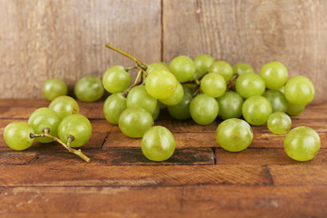 Green grape on wooden table on wooden background