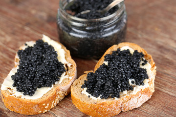 Fototapeta na wymiar Slices of bread with butter and jar of black caviar